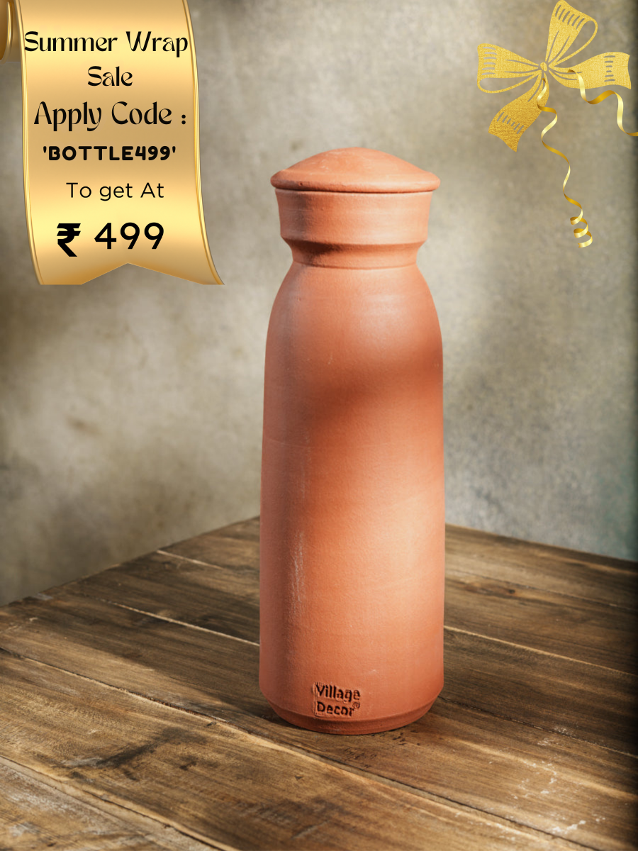 Handmade clay water bottle in traditional matka style by Village Decor, placed on a rustic wooden table.
