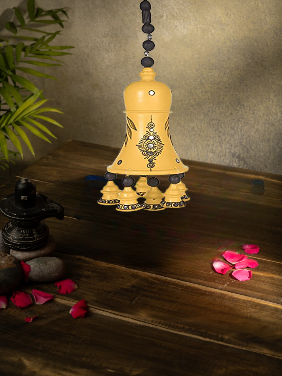 Handcrafted terracotta hanging bell with intricate black floral design, displayed on white background for wall or balcony decor.