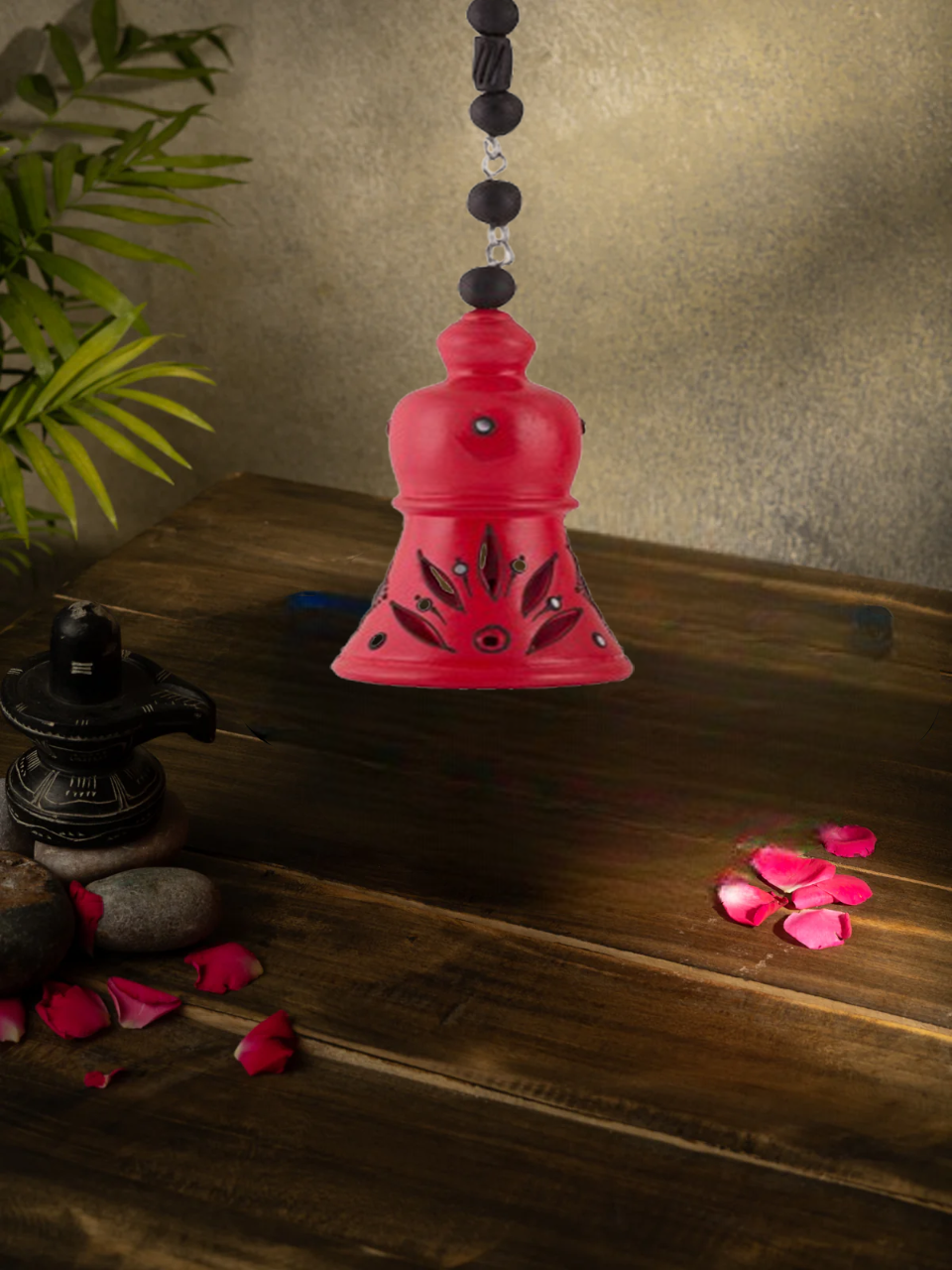 Handcrafted terracotta hanging bell with floral design, perfect for home decor, displayed with rose petals and sunflower background.