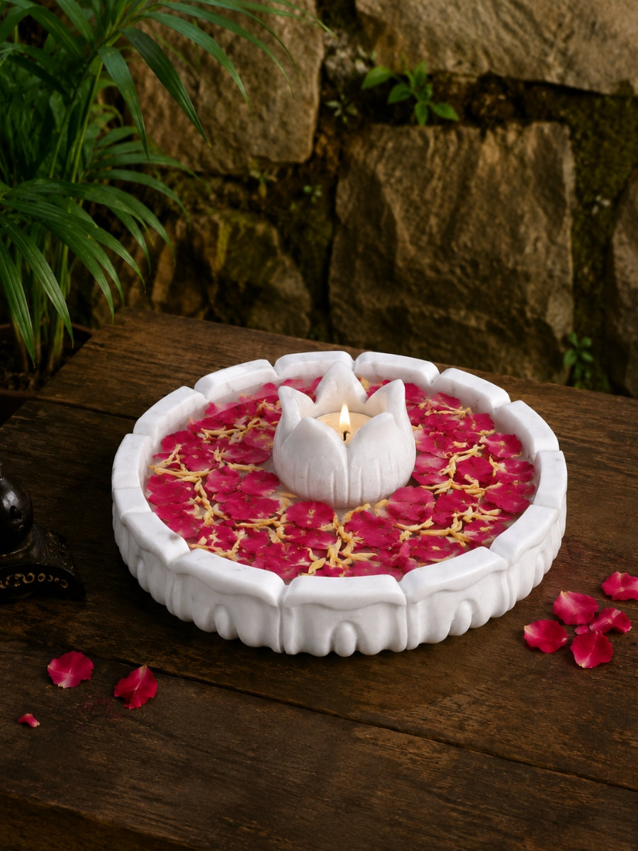 Handcrafted lotus Marble urli with floral design placed on a wooden surface, styled with rose petals and traditional decor for a festive look.