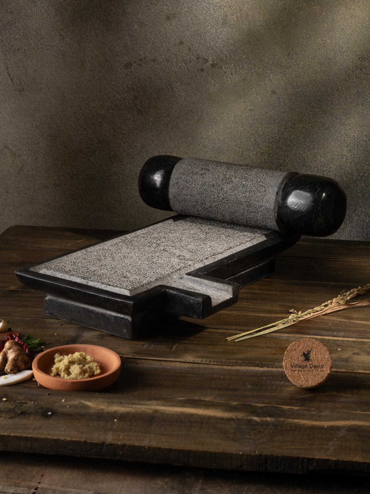 Traditional Handmade silbatta placed on table surrounded by fresh ingredients.