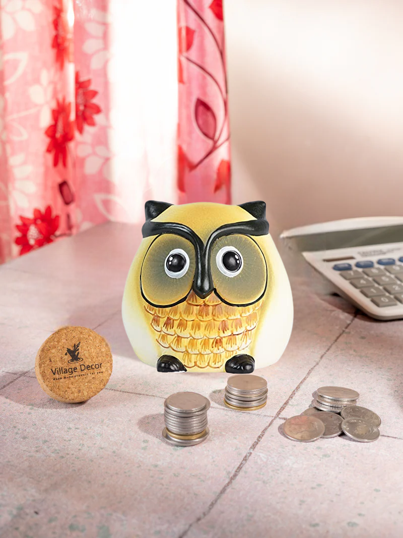Owl-shaped coin Bank with coins and a calculator on a surface with a floral curtain in the background