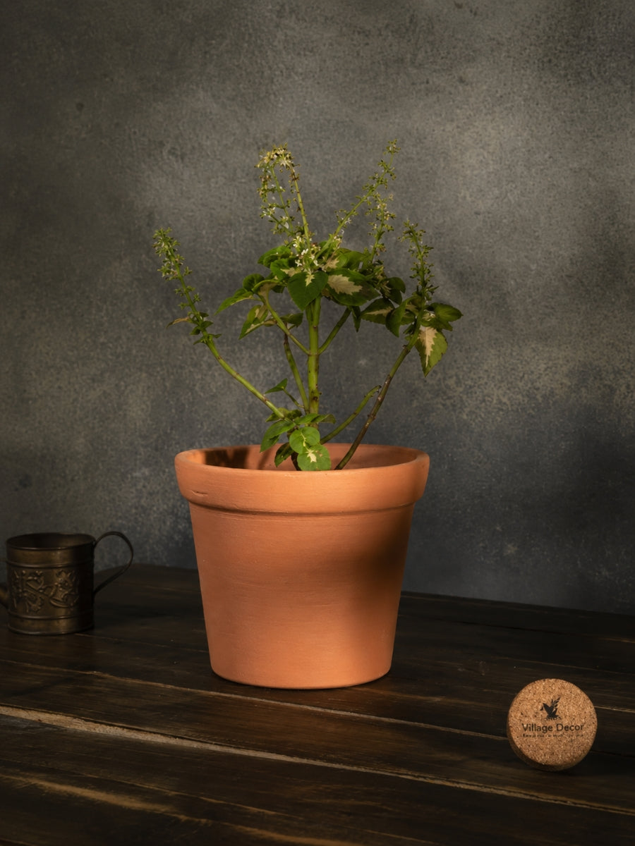 A Terracotta cone-shaped planter Pot, placed indoors with a matching tray. A simple and natural choice for home gardening.