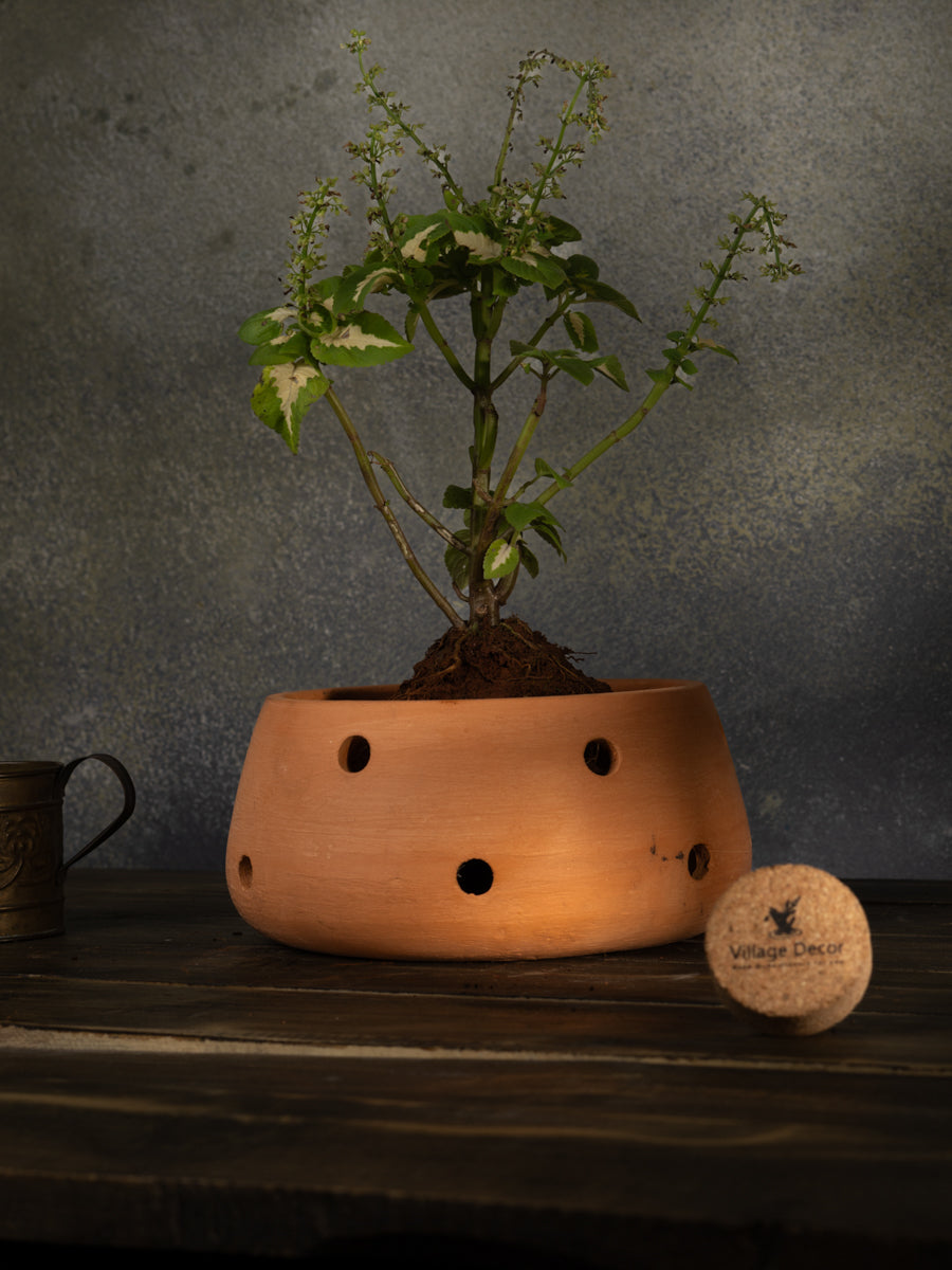 Terracotta indoor flower pot with multiple drainage holes, ideal for garden plants or as a decorative clay planter for home and office spaces.