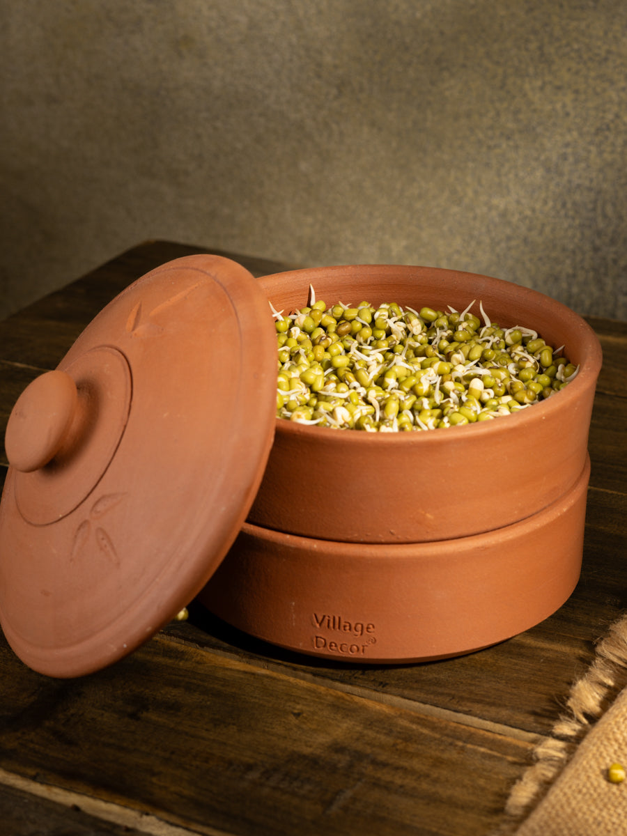 Handcrafted terracotta sprout maker filled with fresh green moong sprouts, placed on a wooden table with warm natural lighting, ideal for healthy and sustainable tableware.