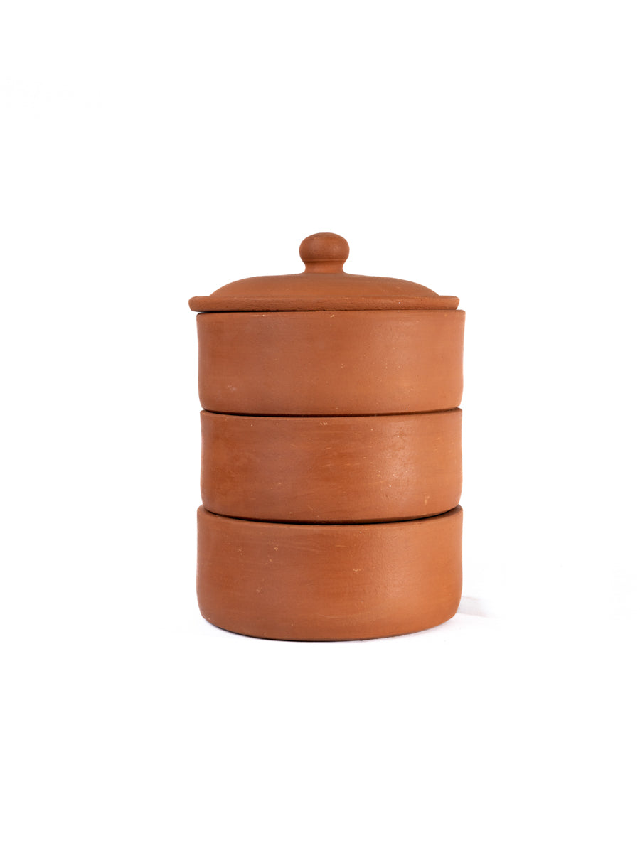 Three tier terracotta sprout maker with lid placed on a plain white background highlighting its natural clay finish and tableware purpose.