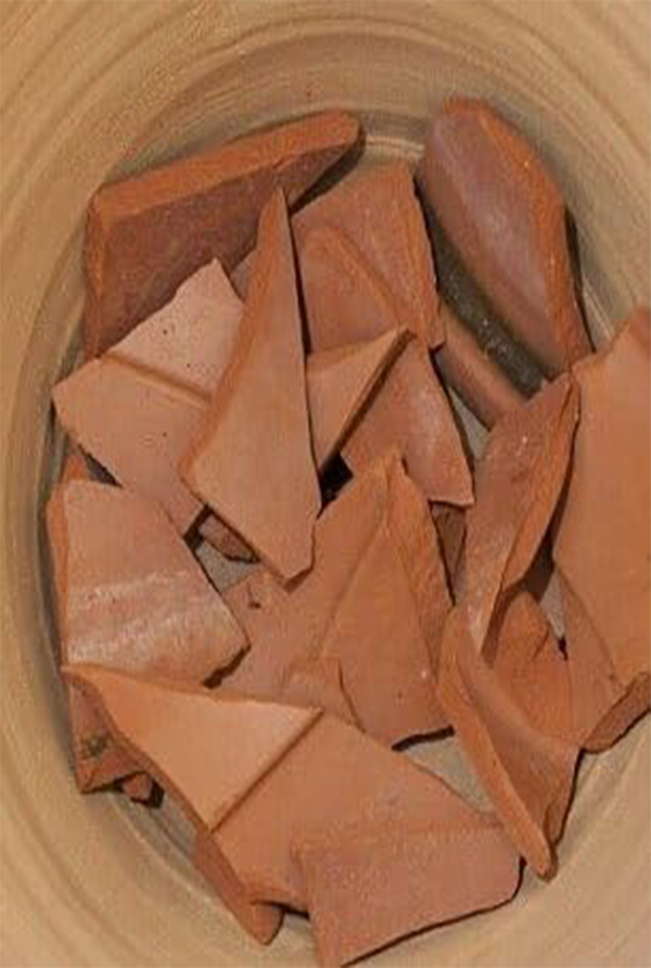 Close-up view of clay chips placed inside a pot, used for improving drainage and soil aeration in gardening.

