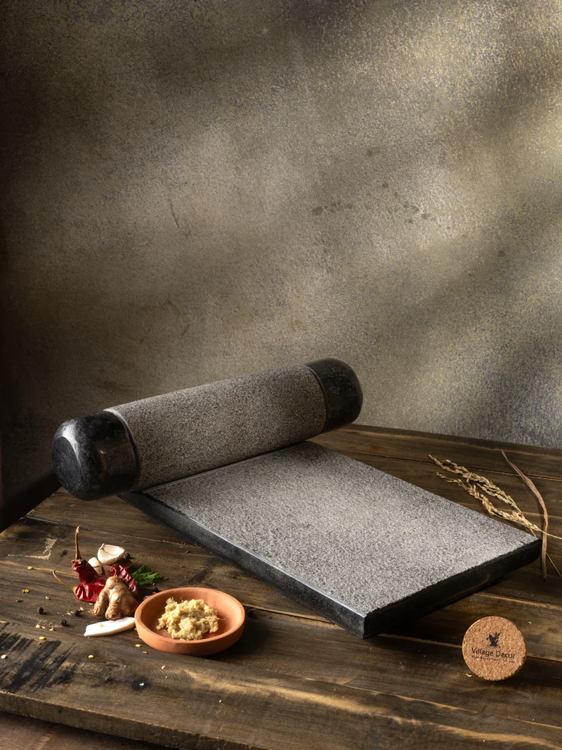 Granite polished sil batta, 15 x 10 inches, styled in a traditional kitchen setting for grinding spices and ingredients using a natural stone mortar and pestle for everyday cooking.