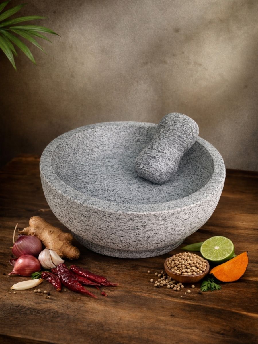Unpolished mortar and pestle filled with spices, placed on a wooden table with garlic, ginger, and chili around it