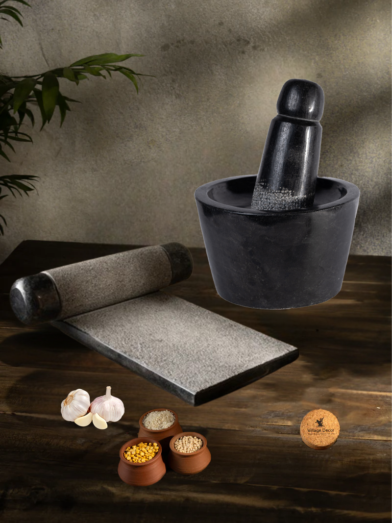 Handmade Silbatta (Ammikal) and Rubbu Rolu (Attukal) stone kitchen tools placed on a rustic wooden surface with lentils and garlic for traditional cooking.

