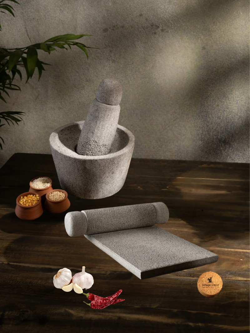 Handmade Silbatta (Ammikal) and Rubbu Rolu (Attukal) stone kitchen tools placed on a rustic wooden surface with lentils and garlic for traditional cooking.
