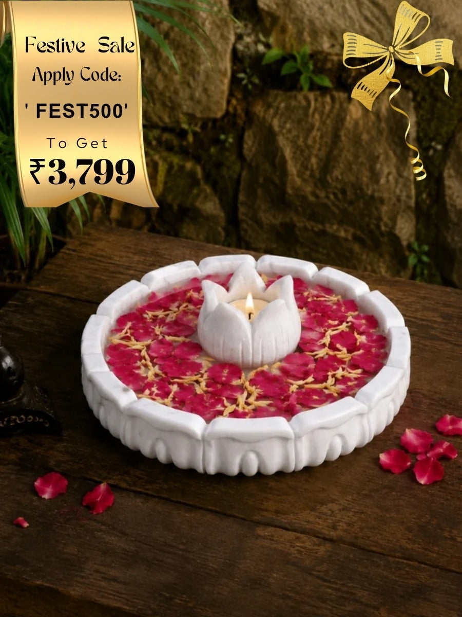 Handcrafted lotus Marble urli with floral design placed on a wooden surface, styled with rose petals and traditional decor for a festive look.
