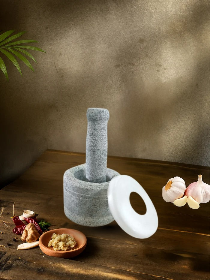 Unpolished mortar and pestle filled with spices, placed on a wooden table with garlic, ginger, and chili around it
