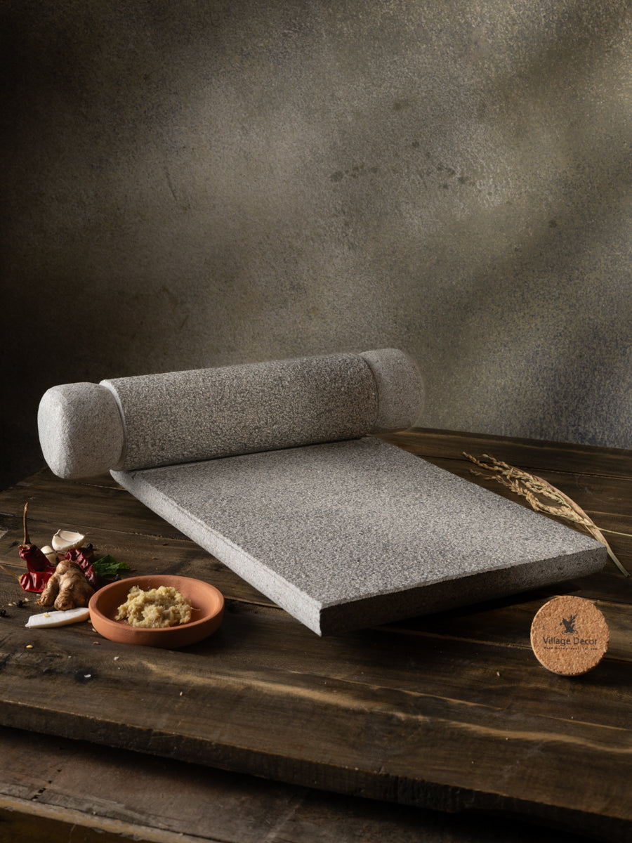 Traditional Handmade silbatta placed on table surrounded by fresh ingredients.