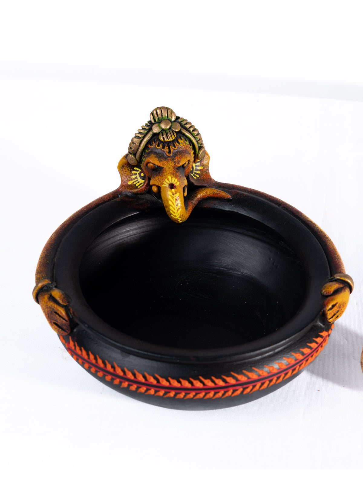 Top view of a colorful handpainted terracotta Ganesha urli with floral art, placed on a white background, ideal for festive decor or pooja setups.
