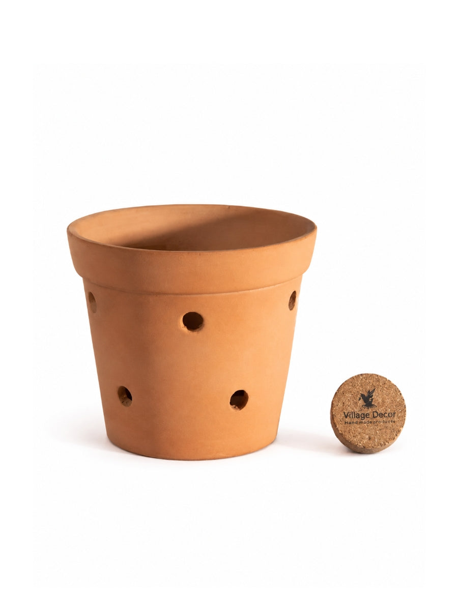 Simple clay planter pot with side drainage holes and a bottom tray, ideal for indoor herbs, small houseplants, or balcony decor.
