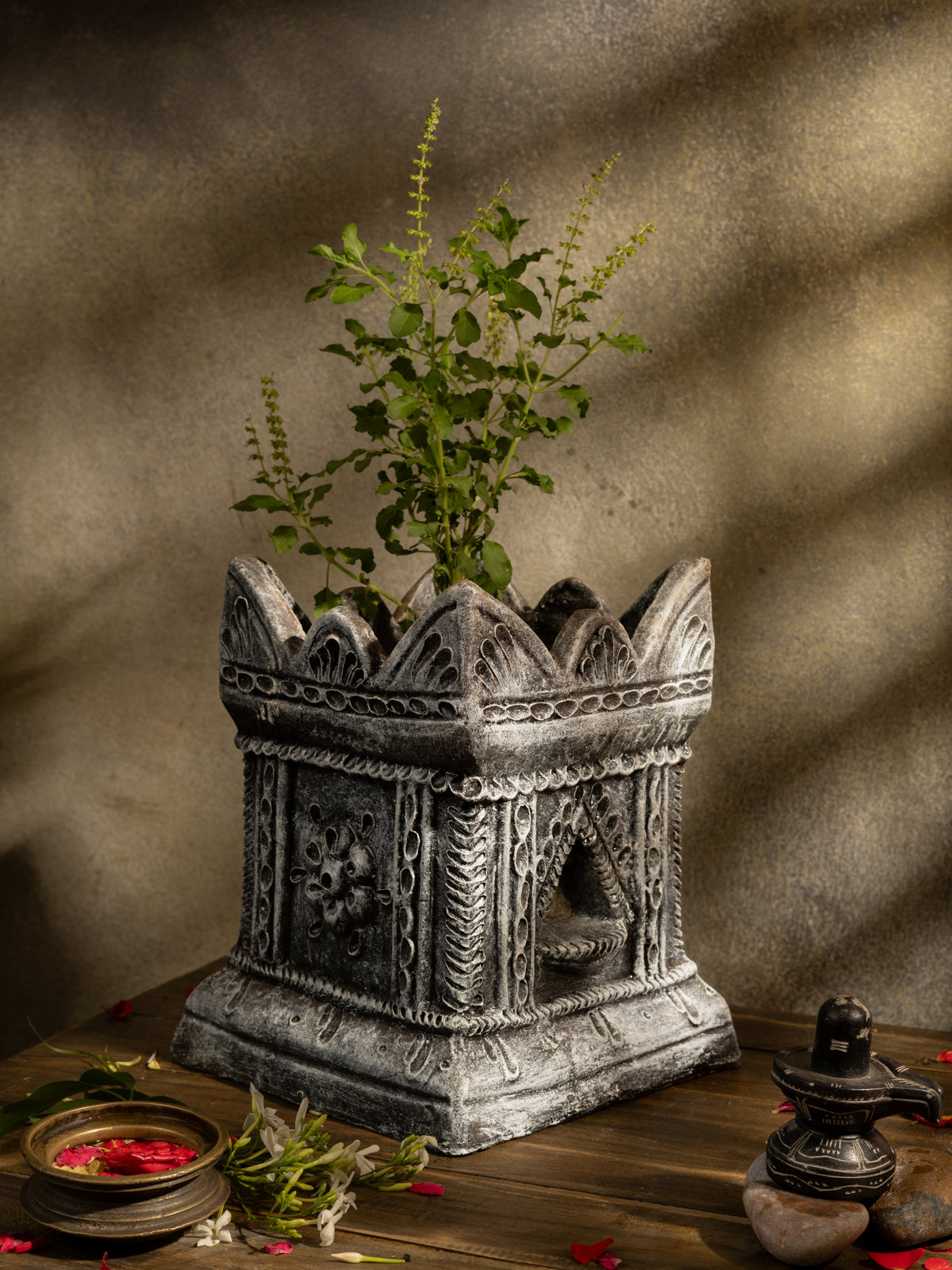 Handcrafted terracotta Tulsi Pot with Tulsi plant in traditional Vrindavan style, placed in a pooja setup with natural lighting and sacred decor.
