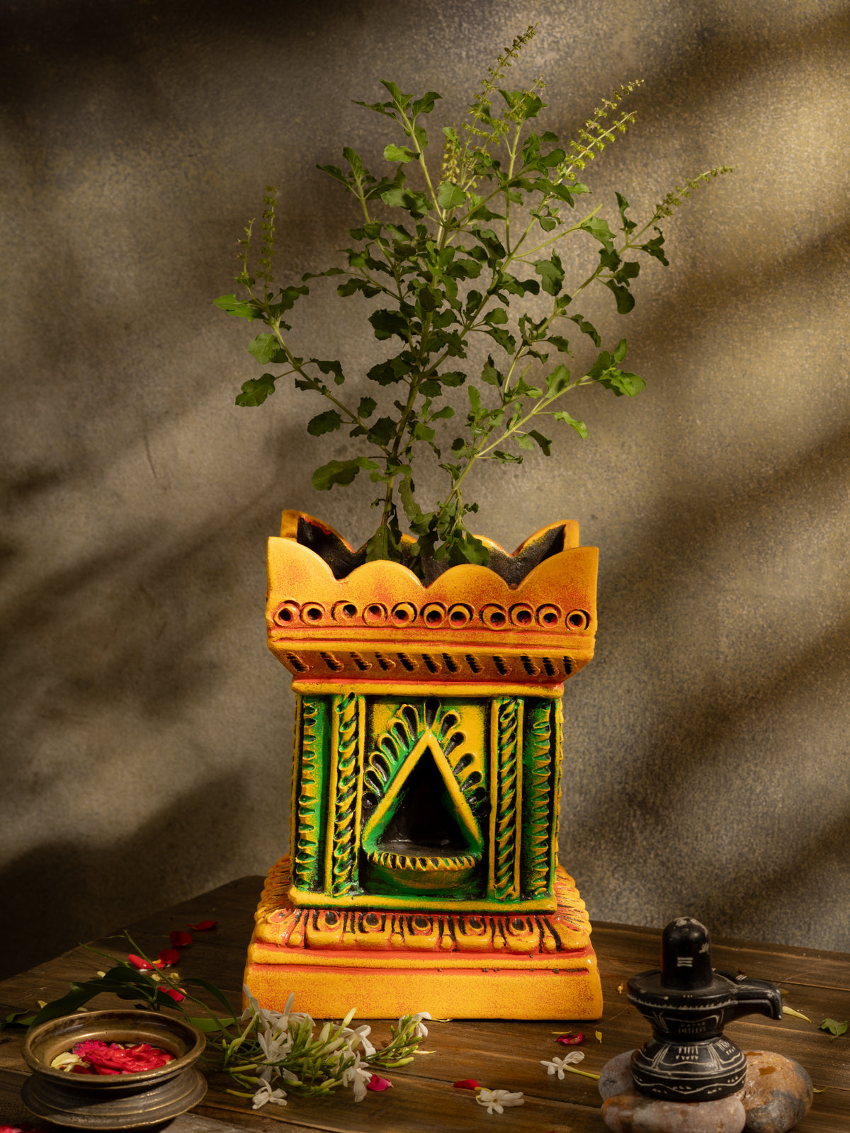 Handcrafted terracotta Tulsi Pot with Tulsi plant in traditional Vrindavan style, placed in a pooja setup with natural lighting and sacred decor.
