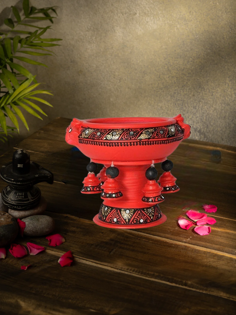 Handcrafted terracotta urli with Handpainted design placed on a wooden surface, styled with rose petals and traditional decor for a festive look.
