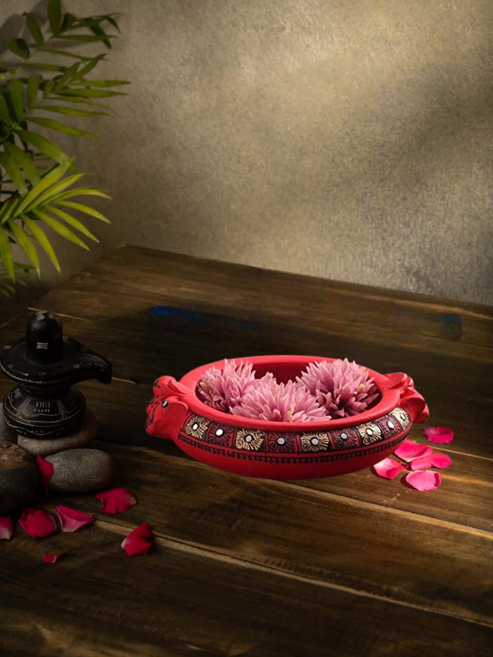Handcrafted multicolor terracotta urli with floral design, styled with rose petals and traditional decor for a festive look.
