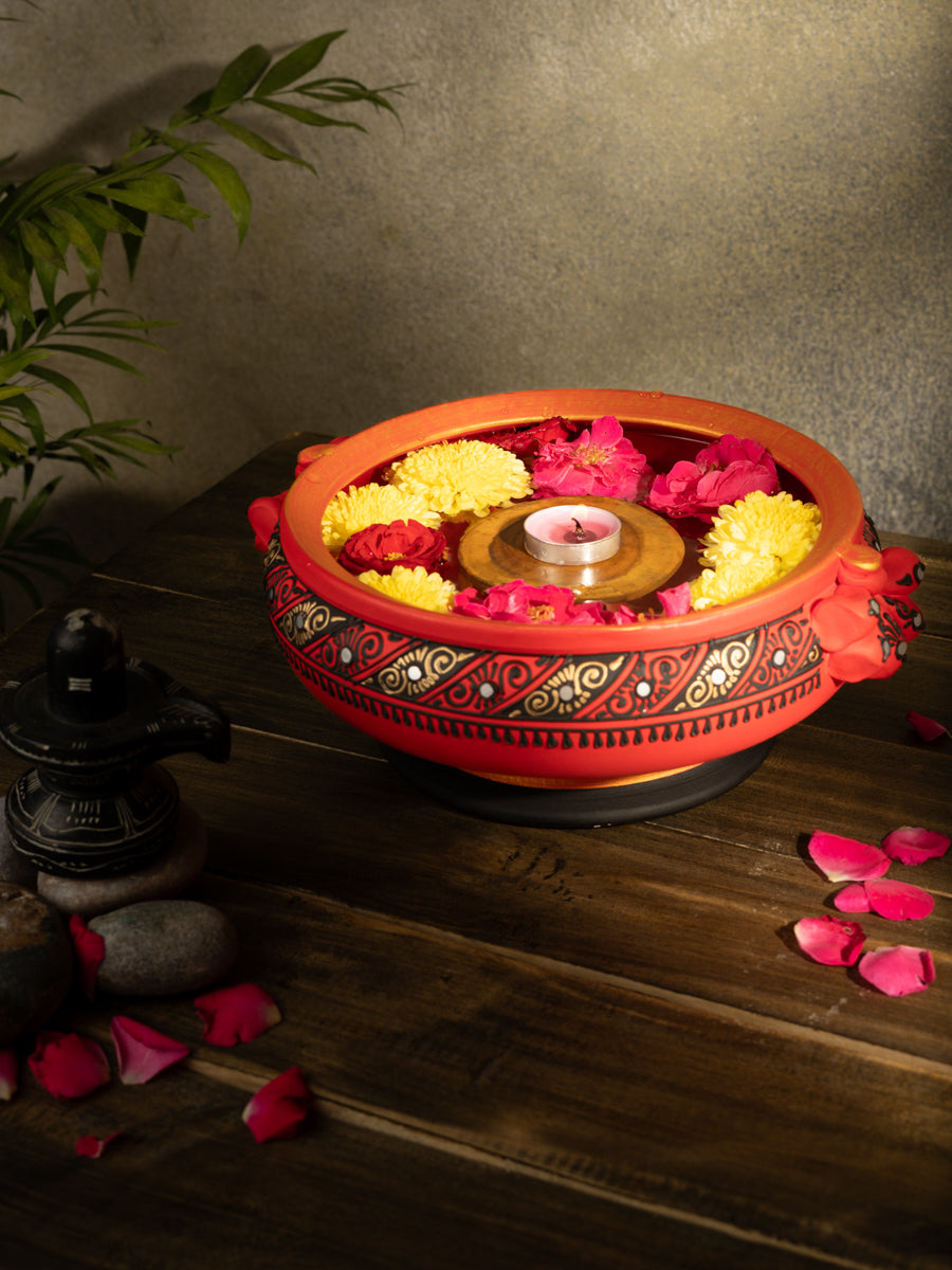 Handcrafted terracotta urli with Handpainted design placed on a wooden surface, styled with rose petals and traditional decor for a festive look.
