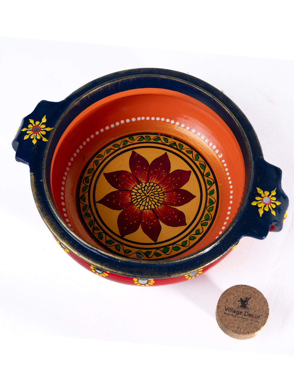 Top view of a colorful handpainted terracotta urli with floral art, placed on a white background, ideal for festive decor or pooja setups.
